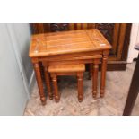 A nest of three carved mahogany tables