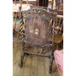 A late Victorian carved walnut fire screen with bergere central design