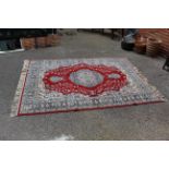 A machine made red ground rug approx.