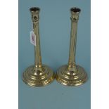 A pair of 18th Century brass candlesticks with fluted stems and gadroon decorated circular bases,