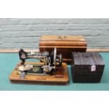A vintage Frister & Rossman sewing machine in a walnut case plus a box with leather covered domed