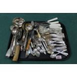 An assortment of flatware including serving spoons, ladles, knives,