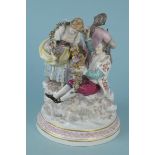 A late 19th Century Dresden figural group of a floral girl and beau with a hurdy gurdy player,