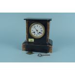 A late 19th Century black marble mantel clock with porcelain dial and red marble columns