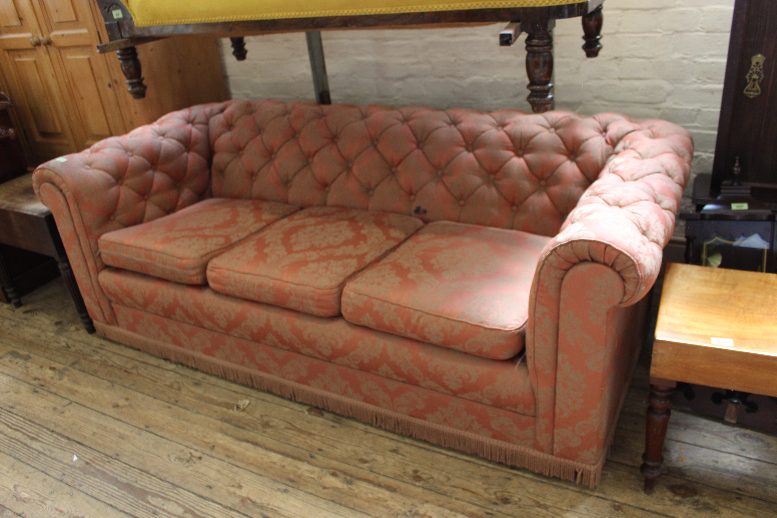 An upholstered three seater Chesterfield style button back sofa