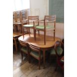 A mid Century teak extending dining table with six upholstered chairs including two carvers