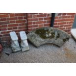 A weathered concrete curved garden seat with squirrel supports