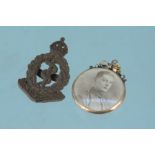 A gold 'open' pendant with photographs plus a Royal Army Medical Corps cap badge