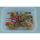 Four WWII medals with a quantity of badges,