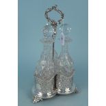 An antique metal and cut glass three bottle tantalus,