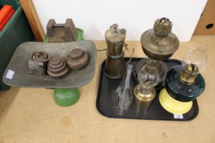 A set of 1920's grocery scales with a copper pan and assorted weights plus four oil lamps