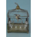 A small mid century brass finish bird cage with ceramic feeders,