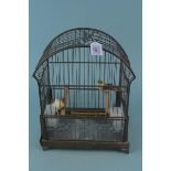 A mid century metal bird cage with ceramic feeders,
