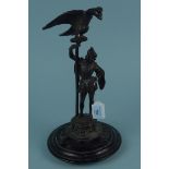 A spelter figure of a Tudor man with a very large eagle above on a wooden base,