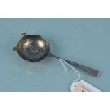 A silver tea strainer,