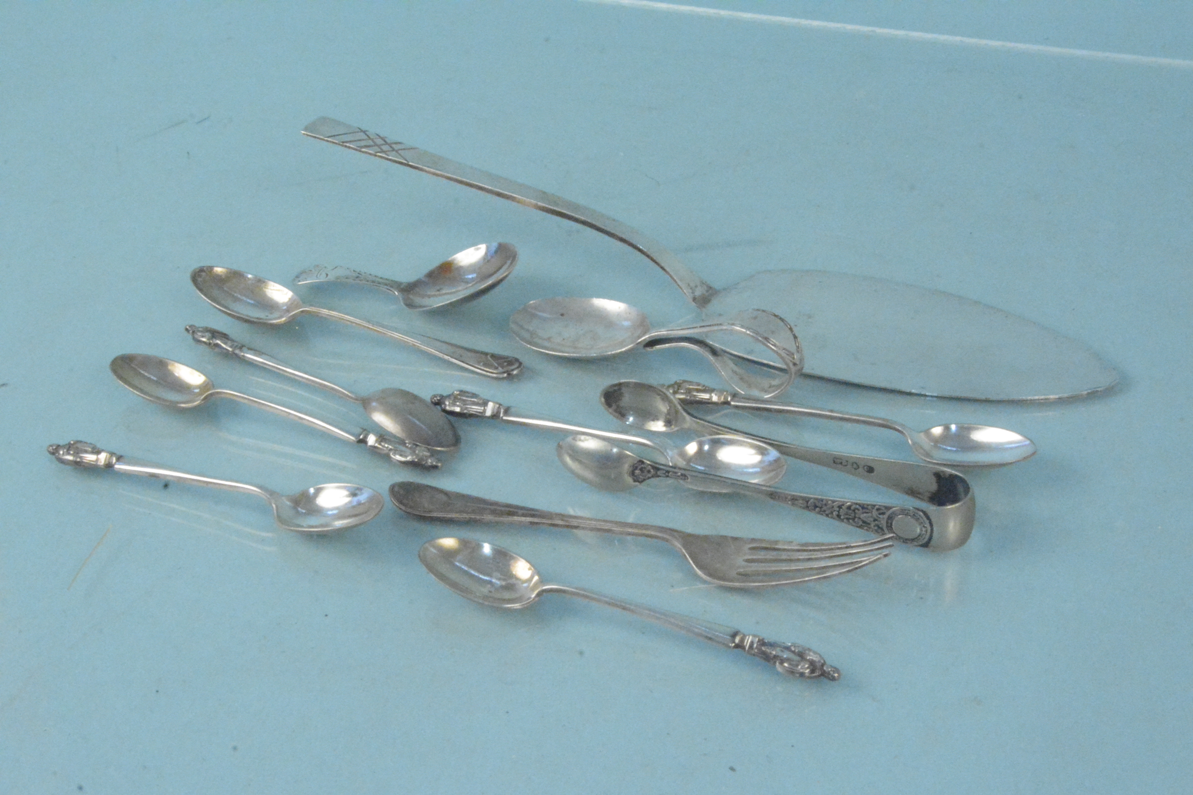 A small selection of silver and silver plated cutlery including a Georgian caddy spoon