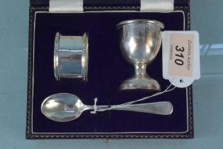 A cased egg cup napkin ring and spoon set,