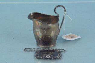 A small silver cream jug and a silver Scotch label, cream jug hallmarked Chester 1912,