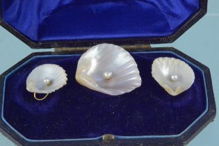 An unusual brooch and earrings set comprising of pearl set natural shell shapes with yellow metal