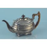 A Georgian silver teapot with wooden handle and engraved crest, hallmarked London 1818,