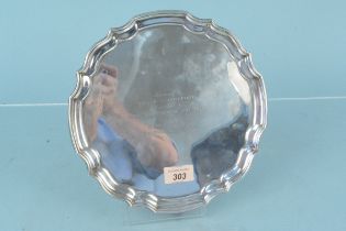 A shaped silver salver with presentation inscription on four feet (one bent),