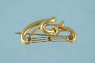 A yellow metal brooch stamped 9ct set with peridot and amethyst stones, weight approx 3.