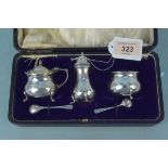 A cased three piece cruet set with associated spoons,