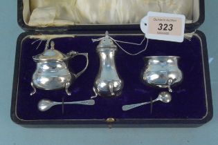 A cased three piece cruet set with associated spoons,