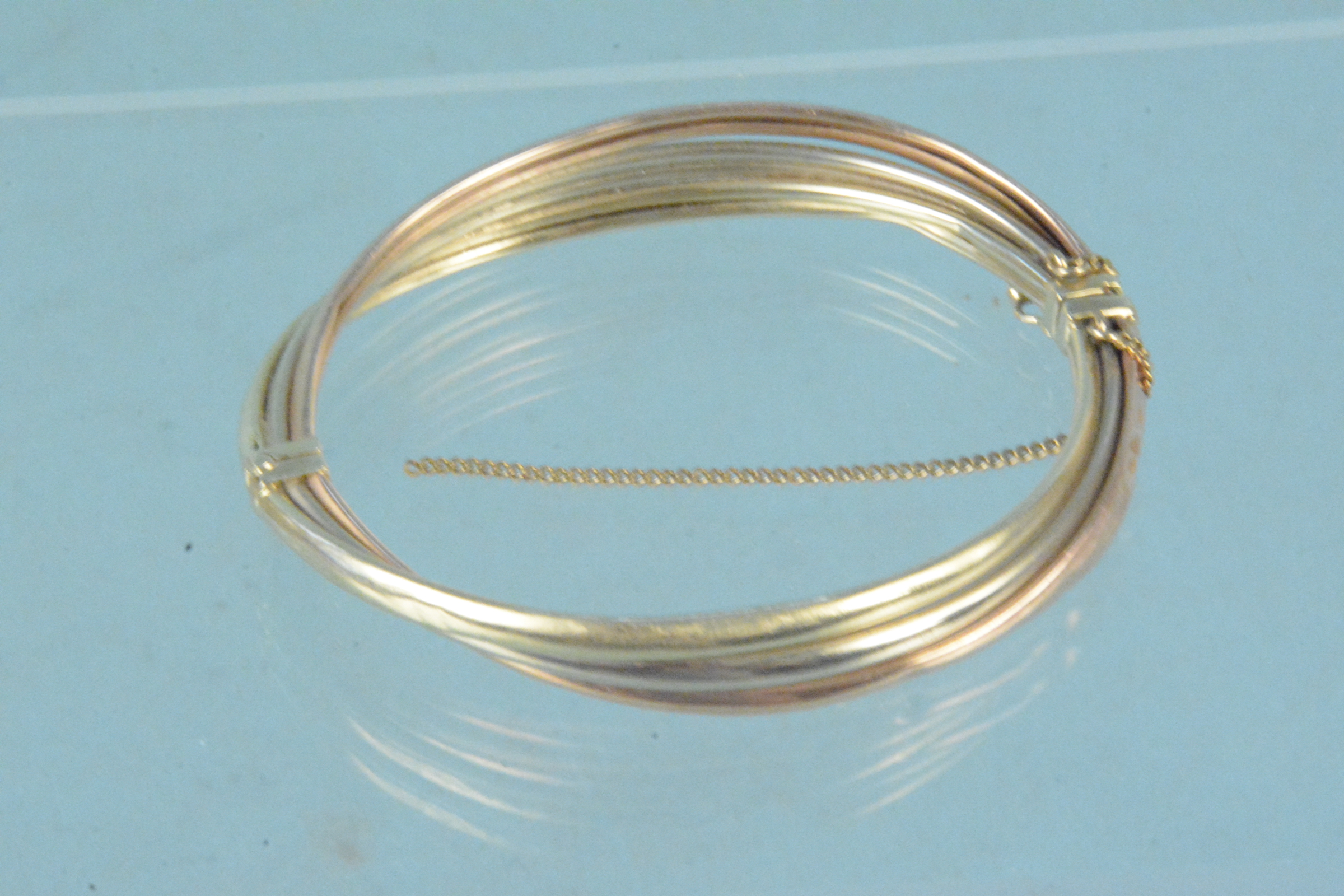 A yellow metal tri-colour bangle, marks rubbed (heavily dented), - Image 2 of 3