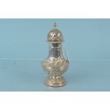 A large silver sugar sifter with embossed decoration, hallmarked Sheffield 1904,