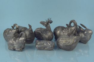 A collection of white metal animal shaped pots
