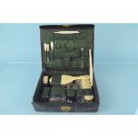 A leather cased vanity travelling set with part contents including four glass silver lidded jars