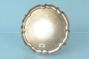 A circular silver salver on three pad feet, hallmarked Sheffield 1945, maker William Bush & Son Ltd,