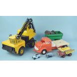 A large Tonka crane together with a trailer and Dinky dump truck,