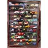 A framed display cabinet with approx eighty plus mainly Lledo collectors cars