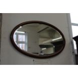 An Edwardian mahogany oval wall mirror