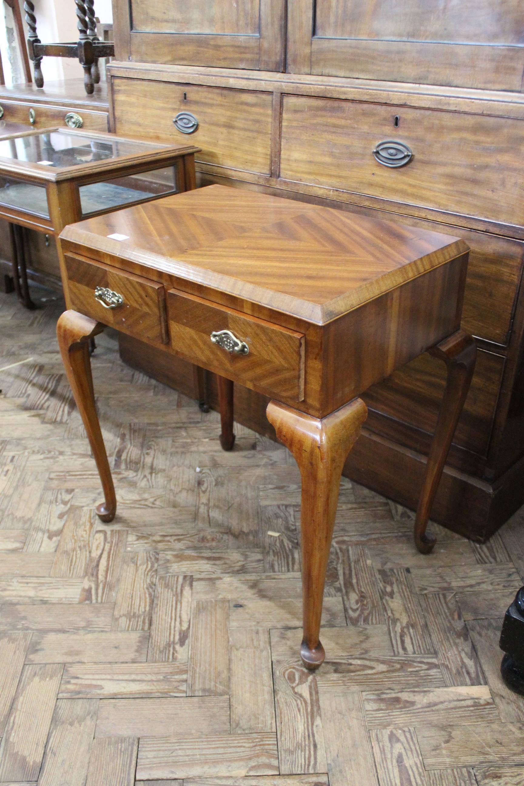 A Queen Anne style two drawer mahogany side table on cabriole legs