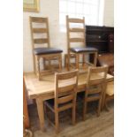 A 20th Century draw leaf table and six ladderback chairs with leather seats