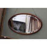 A 1920's oak framed oval wall mirror