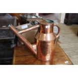 A heavy 19th Century copper watering can of cylindrical milk churn form,