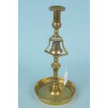 A 19th Century brass tavern candlestick with central column bell and wide dished circular base, 31.