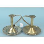 A near pair of large Arts and Crafts brass chambersticks with wide circular dished bases and