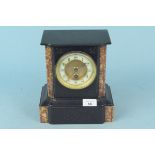 A black marble mantel clock with red marble detailing,