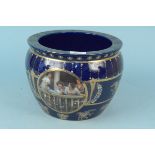 A blue glazed and gilded jardiniere with transfer decoration of ladies on a balcony,
