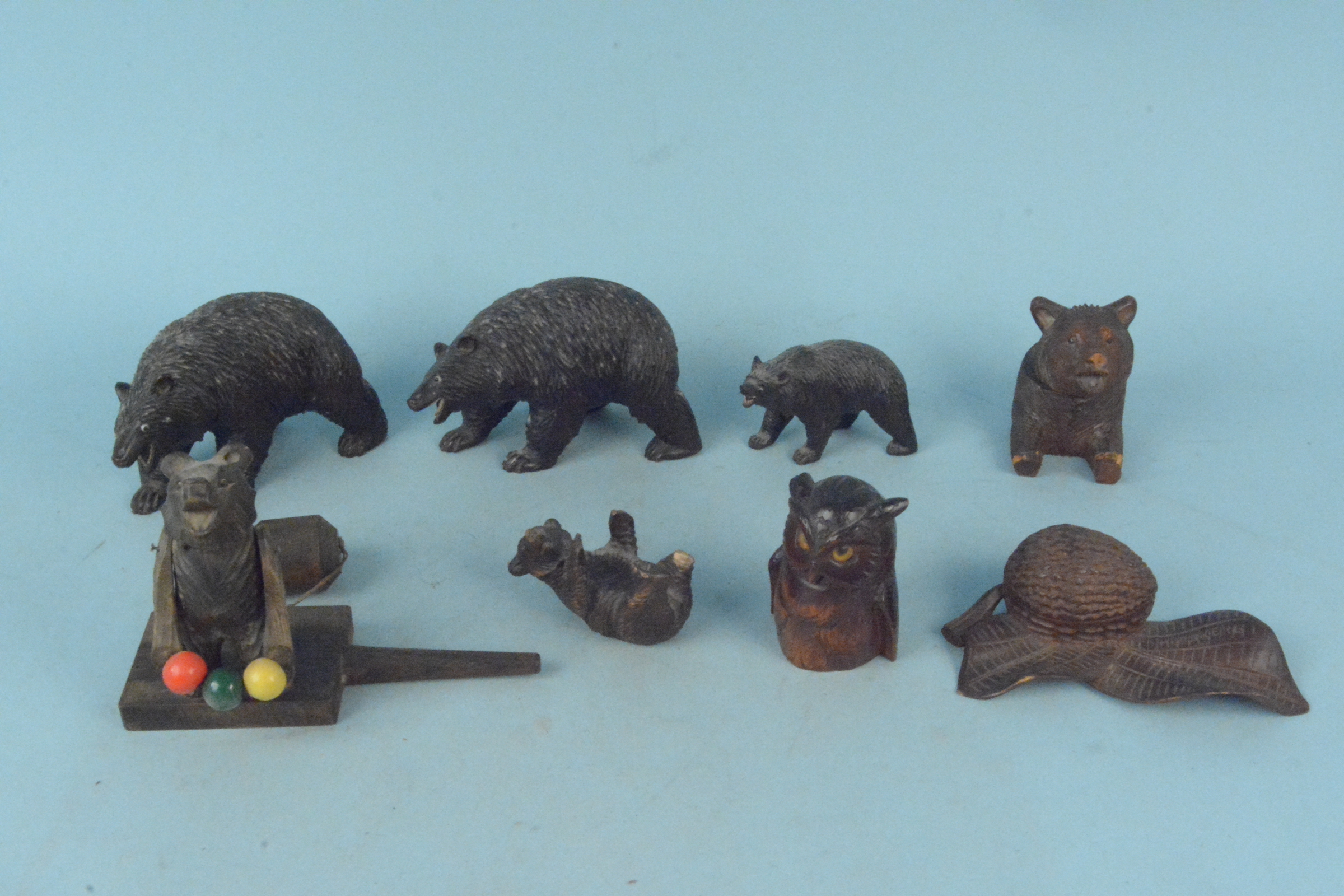 Five Black Forest carved wooden bears a carved owl inkwell and a wooden performing bear toy