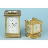 A brass carriage clock retailed by St James, London together with a rotating desk clock featuring