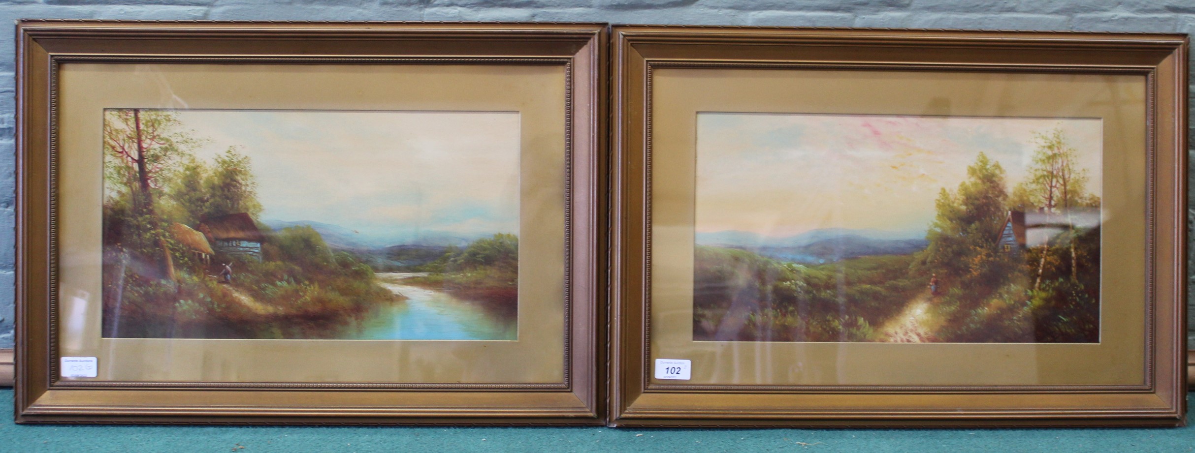 A pair of unsigned gilt framed watercolours of rural cottage scenes,