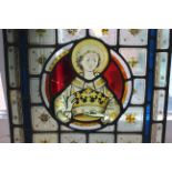 An antique stained glass panel depicting a Christian Saint,
