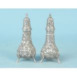 A pair of sterling silver foliate embossed peppers, stamped to base (one rubbed),
