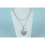 A large silver photograph locket with ribbed and engraved floral decoration on long silver chain